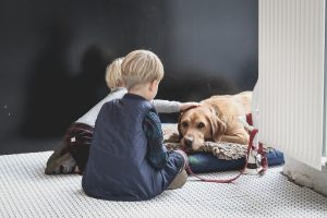 children comforting pet dog