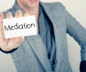 Woman holding card that says mediation