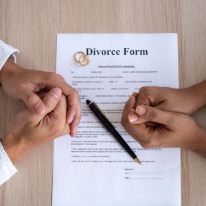 Husband and Wives hands folded on top of a divorce decree.