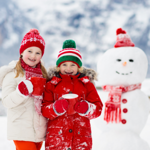 Kids in the snow next to a snowman